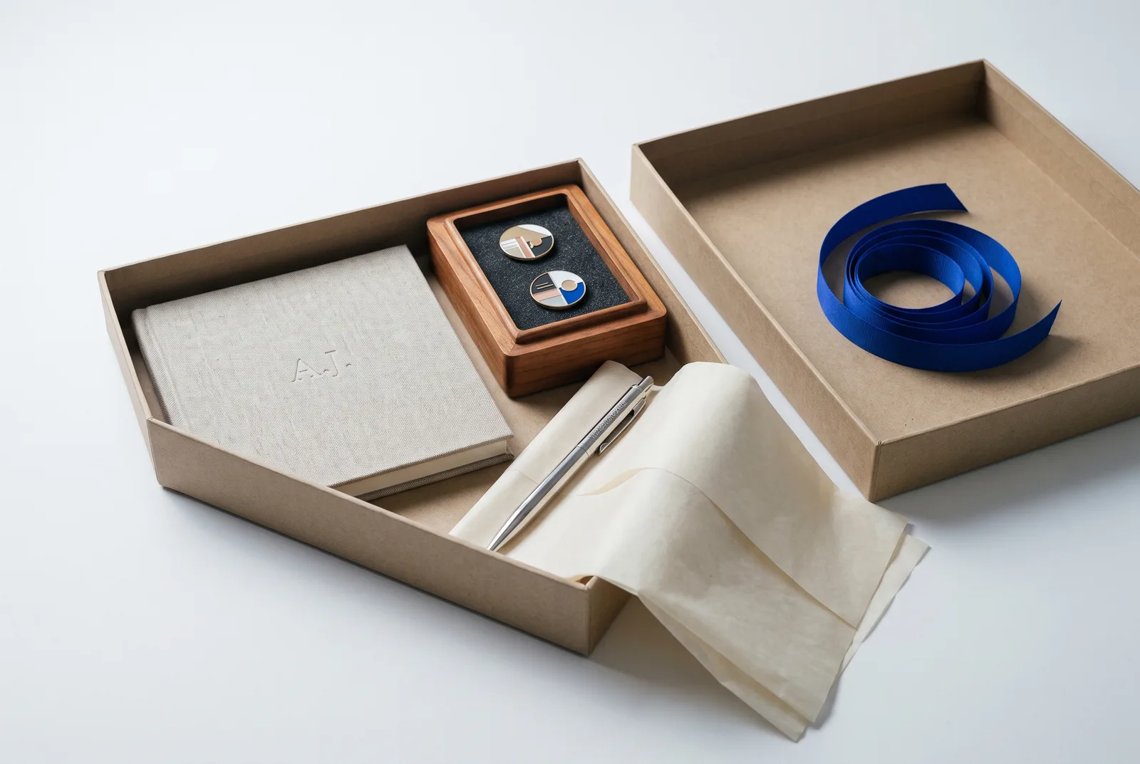 Open corporate gift box with notebook, pins and pen